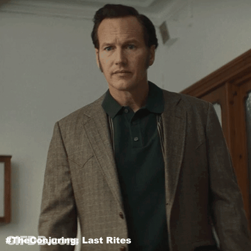 A Man Wearing A Suit And A Green Polo Shirt With The Conjuring Last Rites Written On The Bottom GIF