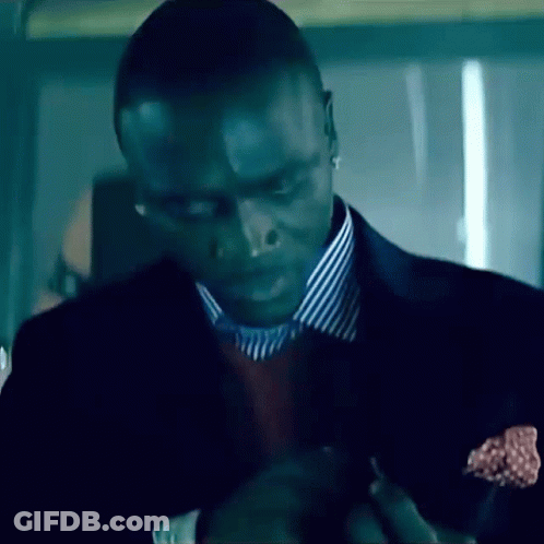 A Man Wearing A Suit And Striped Shirt Is Looking Down GIF