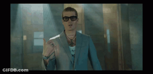 A Man Wearing A Suit And Sunglasses Is Giving A Thumbs Up Sign GIF