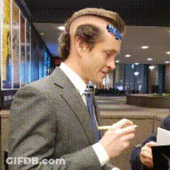 A Man Wearing A Suit And Tie Has A Sticker On His Head GIF