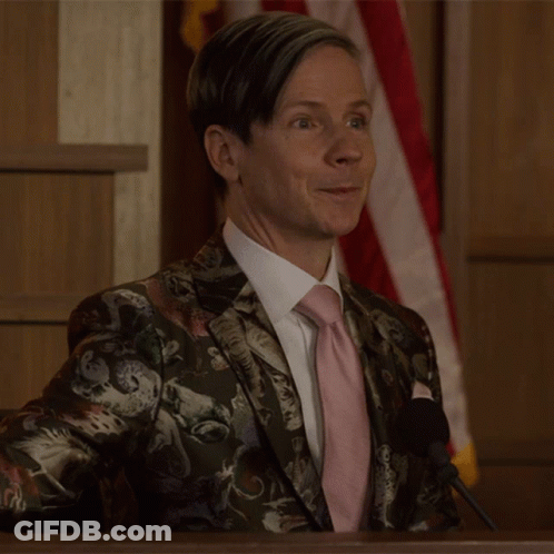 A Man Wearing A Suit And Tie Is Giving A Thumbs Up GIF