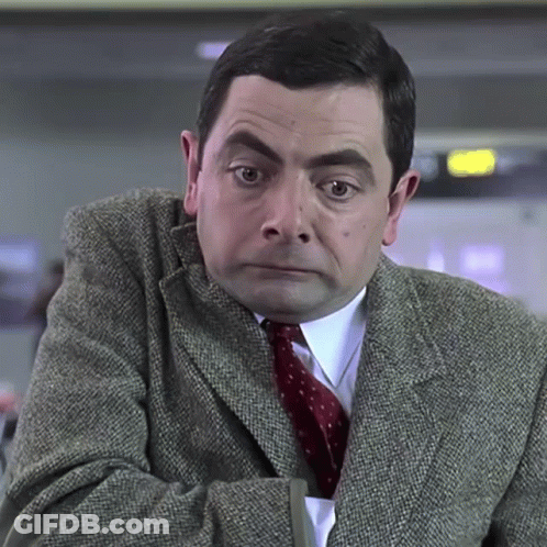 A Man Wearing A Suit And Tie Is Looking At The Camera GIF