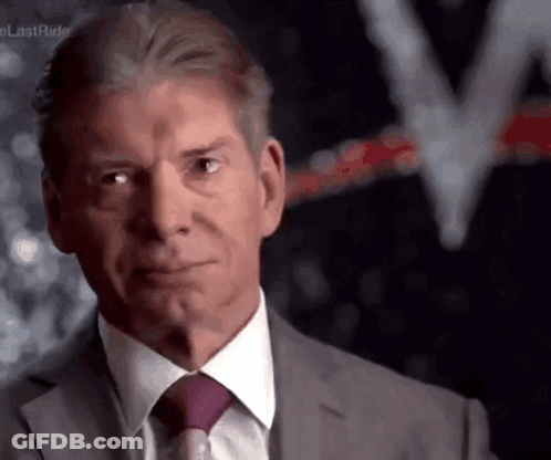 A Man Wearing A Suit And Tie Is Looking At The Camera GIF