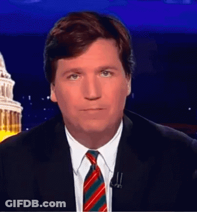 A Man Wearing A Suit And Tie Is Looking At The Camera GIF
