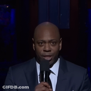 A Man Wearing A Suit And Tie Is Making A Funny Face GIF