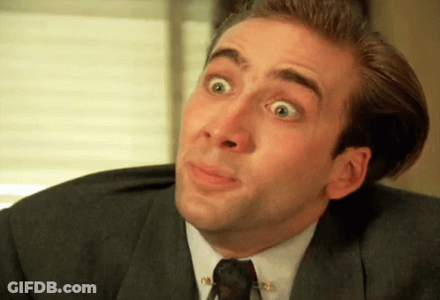 A Man Wearing A Suit And Tie Is Making A Funny Face GIF