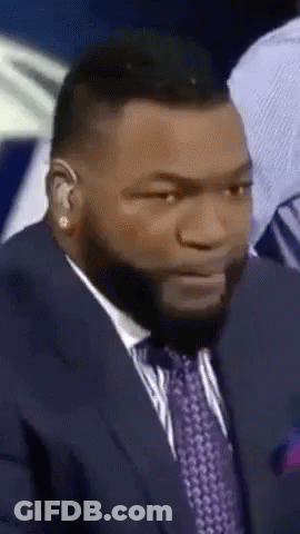 A Man Wearing A Suit And Tie Is Making A Funny Face GIF