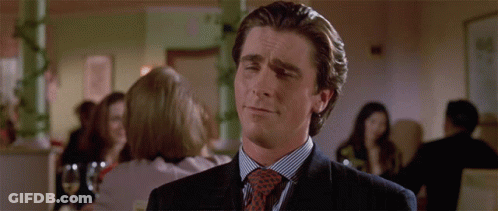 A Man Wearing A Suit And Tie Is Making A Funny Face GIF