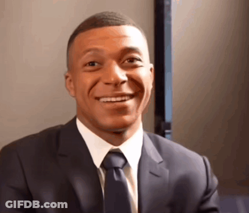 A Man Wearing A Suit And Tie Is Smiling GIF