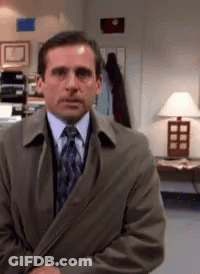 A Man Wearing A Suit And Tie Is Standing In Front Of A Lamp GIF