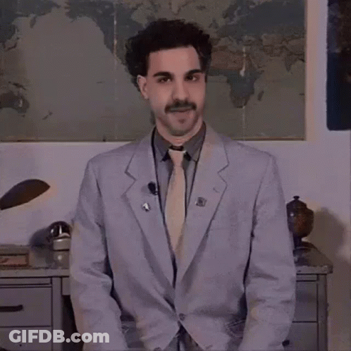 A Man Wearing A Suit And Tie Is Standing In Front Of A Map Of The World . GIF