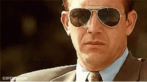 A Man Wearing A Suit And Tie Is Wearing Sunglasses GIF