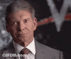 A Man Wearing A Suit And Tie Looks At The Camera GIF