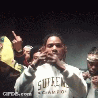 A Man Wearing A Supreme Champion Sweatshirt Is Standing In Front Of A Crowd Of People . GIF