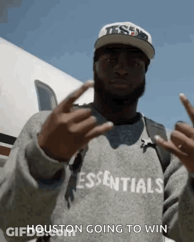 A Man Wearing A Sweatshirt That Says Essentials On It GIF