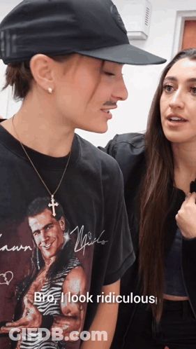 A Man Wearing A T-Shirt That Says " Bro I Look Ridiculous " Talks To A Woman GIF