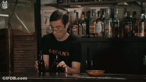 A Man Wearing A T-Shirt That Says Dsans Holds A Bottle GIF