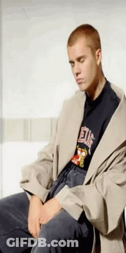 A Man Wearing A T-Shirt That Says Elf Is Sitting Down GIF