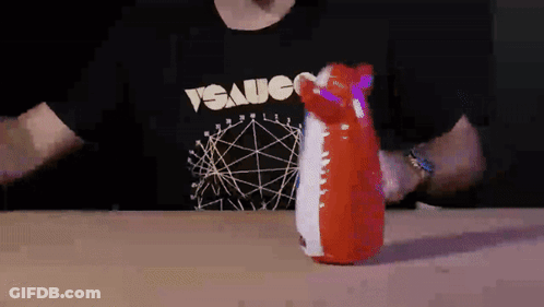 A Man Wearing A T-Shirt That Says " Sauce " Is Holding A Red And White Inflatable Animal GIF