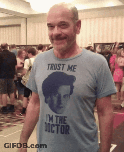 A Man Wearing A T-Shirt That Says " Trust Me I 'M The Doctor " GIF