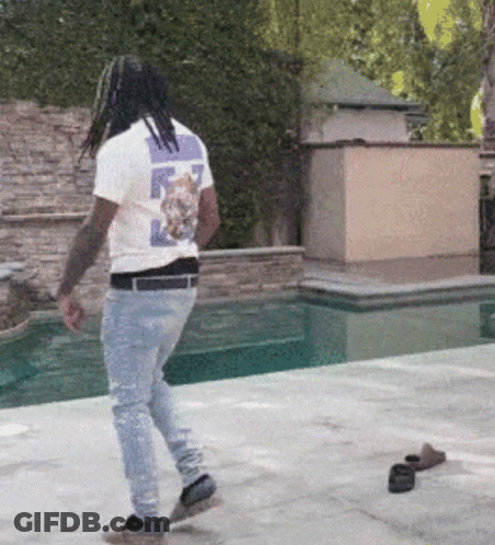 A Man Wearing A T-Shirt With A Cat On The Back Walks By A Pool GIF