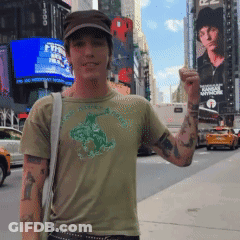 A Man Wearing A T-Shirt With A Horse On It Is Standing In Front Of A Billboard That Says Fox GIF