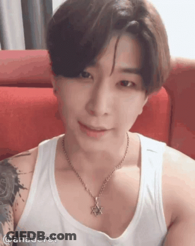 A Man Wearing A Tank Top And A Necklace With A Star On It GIF