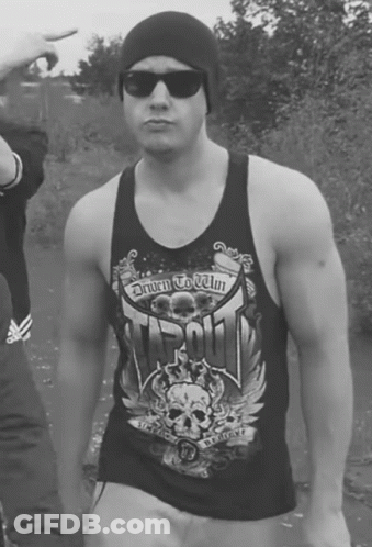 A Man Wearing A Tank Top That Says Driven To Win On It GIF