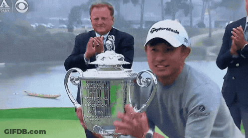 A Man Wearing A Taylormade Hat Holds Up A Trophy GIF