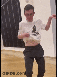 A Man Wearing A Tedom Shirt Is Dancing In A Dance Studio GIF