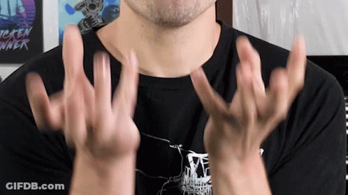 A Man Wearing A Tekken Runner Shirt Holds His Hands Up In The Air GIF