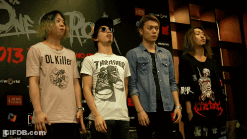A Man Wearing A Thrasher Shirt Stands In Front Of A Sign That Says 2013 GIF