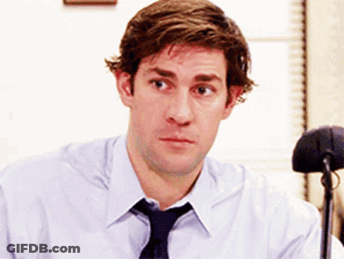 A Man Wearing A Tie And A White Shirt Is Looking At The Camera GIF