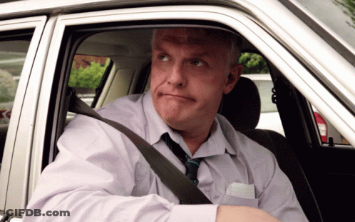 A Man Wearing A Tie Is Sitting In A Car And Looking Out The Window GIF