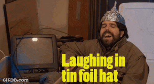 A Man Wearing A Tin Foil Hat Laughs In Front Of A Computer GIF