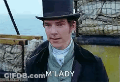 A Man Wearing A Top Hat And A Suit Is Standing In Front Of A Boat . GIF