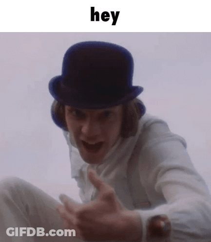 A Man Wearing A Top Hat And A White Shirt Is Making A Funny Face And Saying Hey . GIF