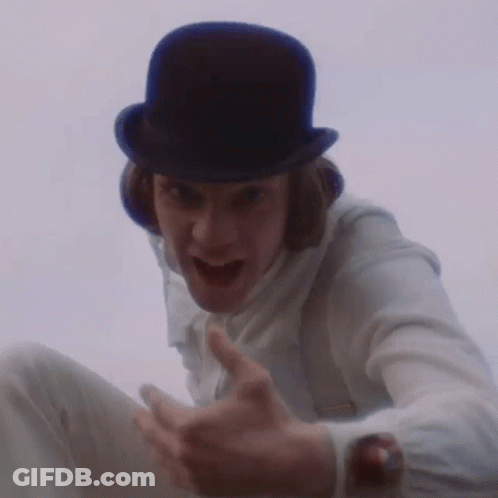 A Man Wearing A Top Hat And Suspenders Is Making A Funny Face GIF