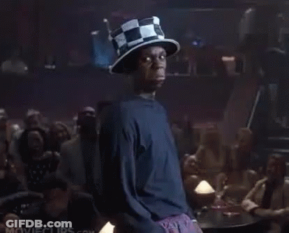 A Man Wearing A Top Hat Is Standing In Front Of A Crowd Of People In A Bar . GIF
