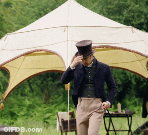 A Man Wearing A Top Hat Is Standing In Front Of A Tent GIF