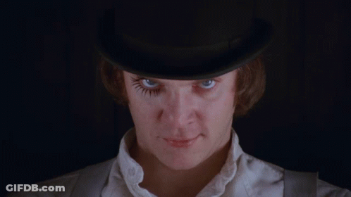 A Man Wearing A Top Hat With A Fake Eyelash On His Eye GIF