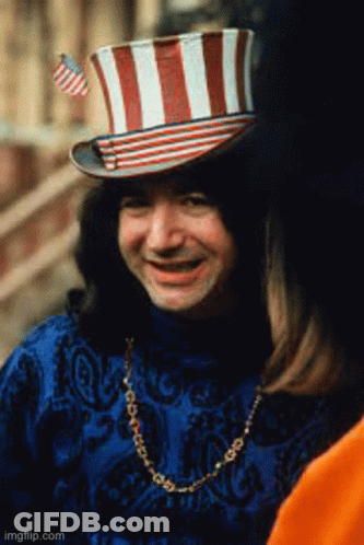 A Man Wearing A Top Hat With A Flag On It GIF