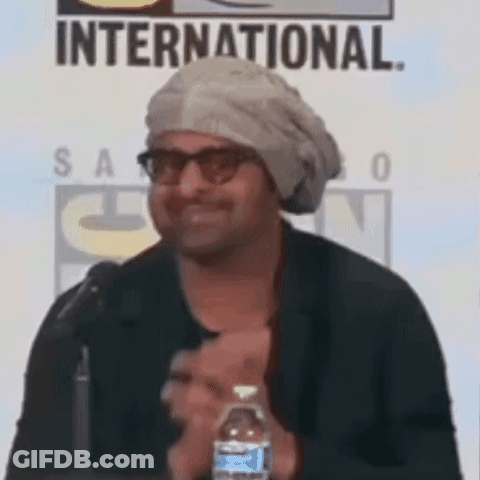 A Man Wearing A Turban And Glasses Is Holding A Bottle Of Water . GIF