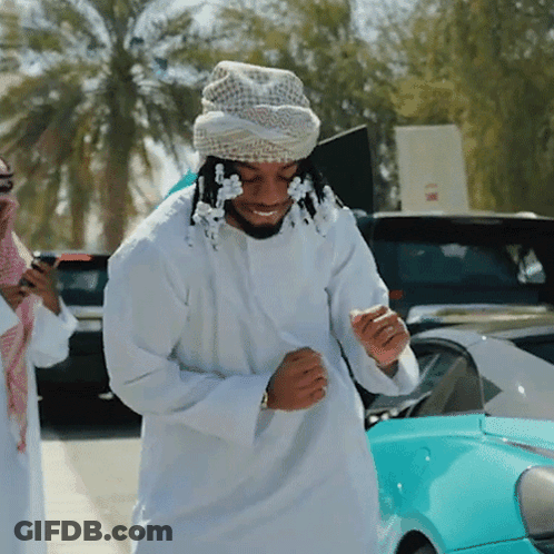 A Man Wearing A Turban Is Standing In Front Of A Car GIF