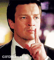 A Man Wearing A Tuxedo And Bow Tie Is Holding His Finger To His Mouth . GIF
