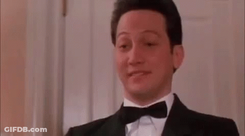 A Man Wearing A Tuxedo And Bow Tie Is Making A Funny Face . GIF