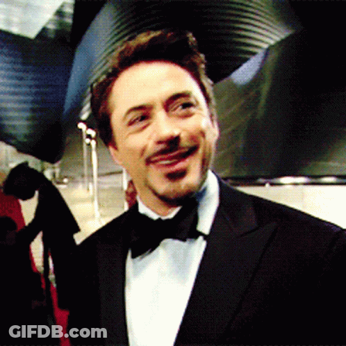 A Man Wearing A Tuxedo And Bow Tie Is Smiling GIF