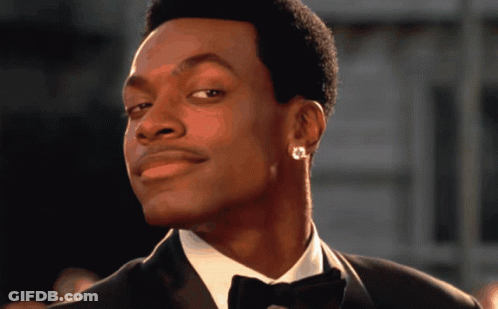 A Man Wearing A Tuxedo And Earrings Looks To The Side GIF