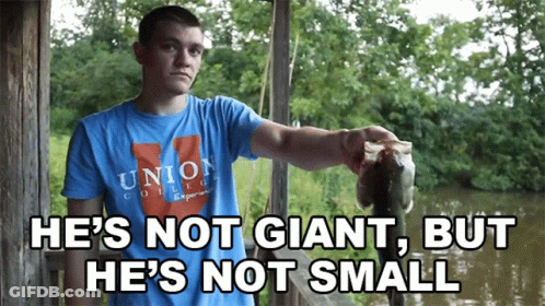 A Man Wearing A Union College Shirt Holds A Large Fish GIF