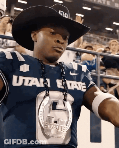A Man Wearing A Utah State Jersey With A Cowboy Hat GIF